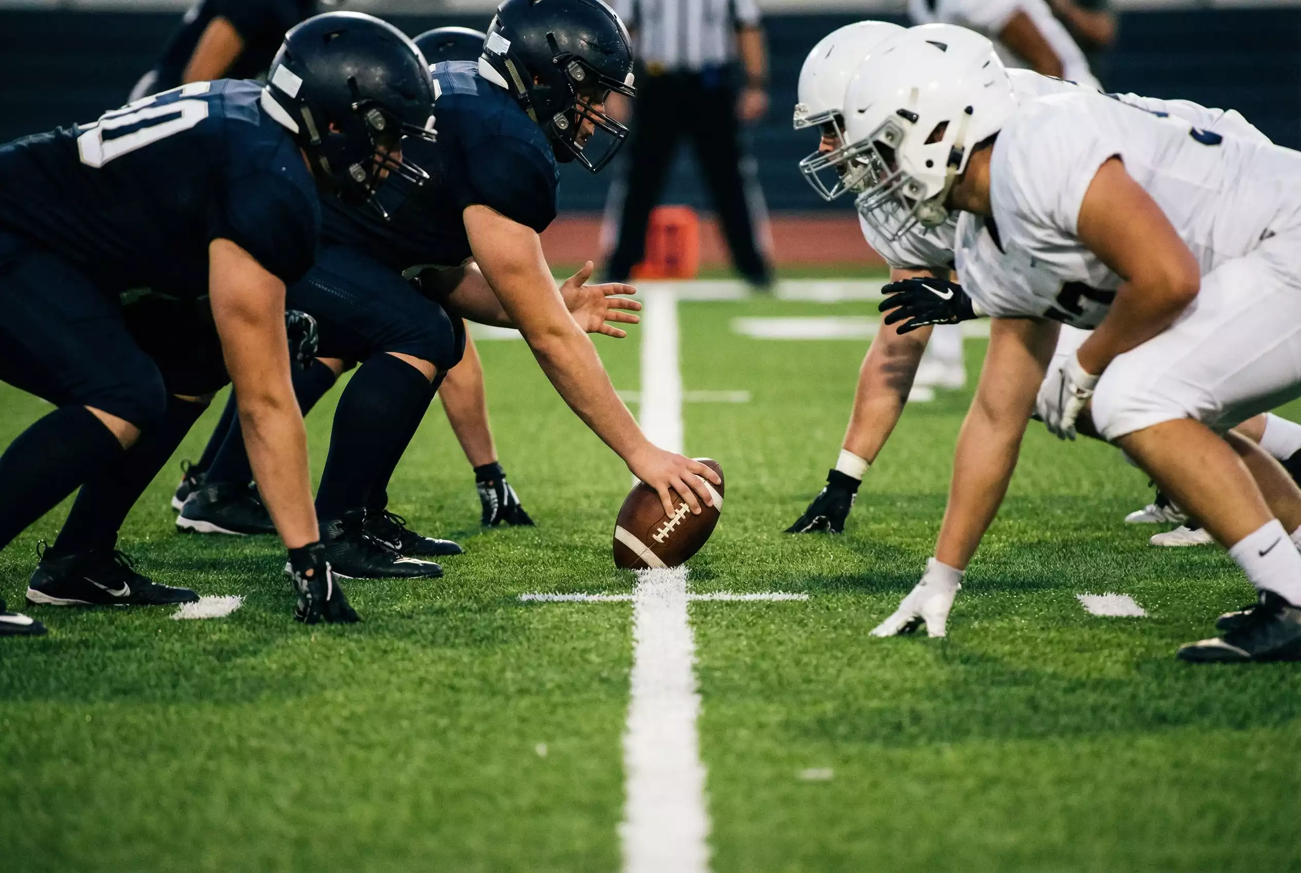 American Football Spielzug an der Line of Scrimmage mit Offense und Defense in Aufstellung