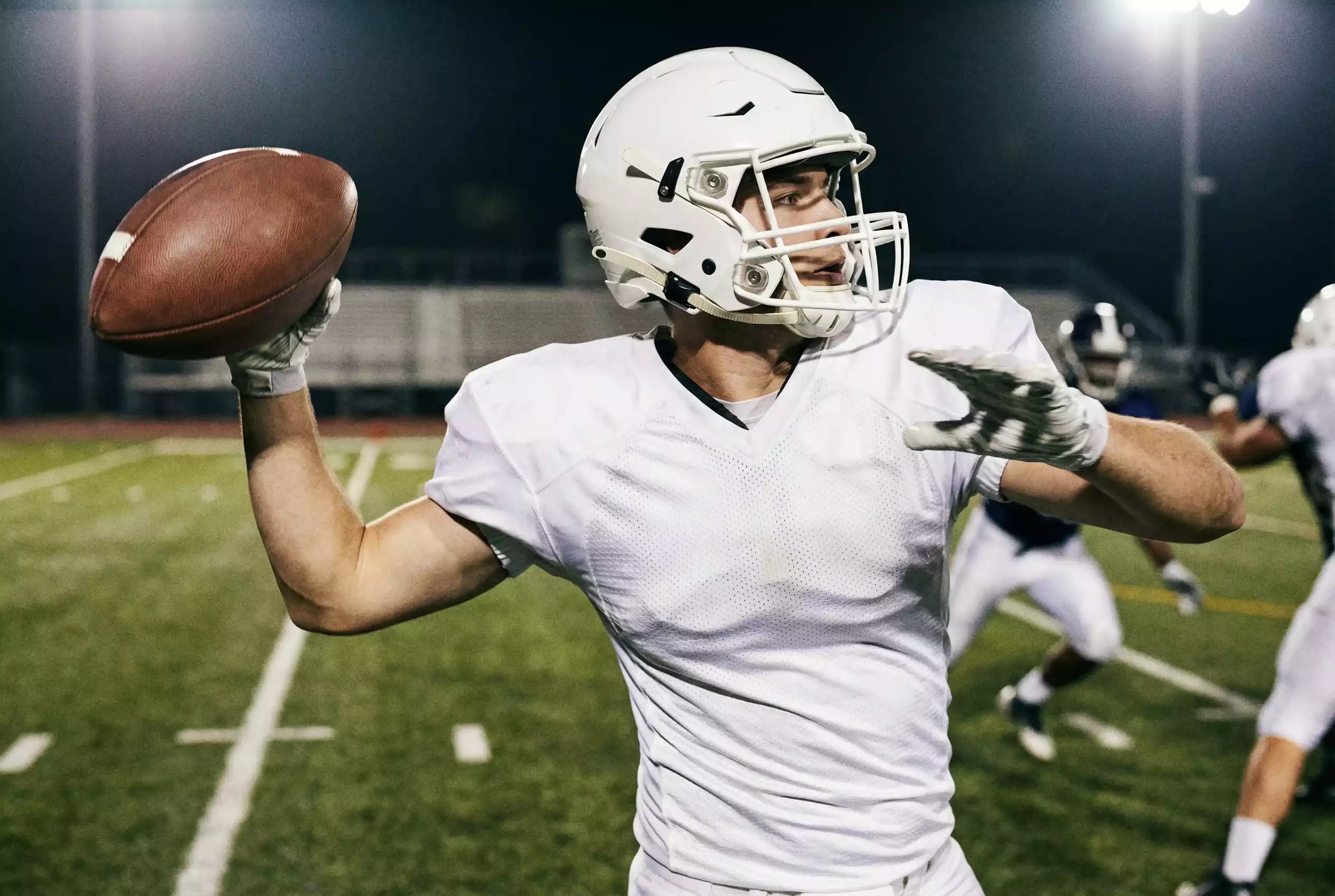 NFL Quarterback wirft einen Pass während eines Spielzugs auf dem Football-Feld